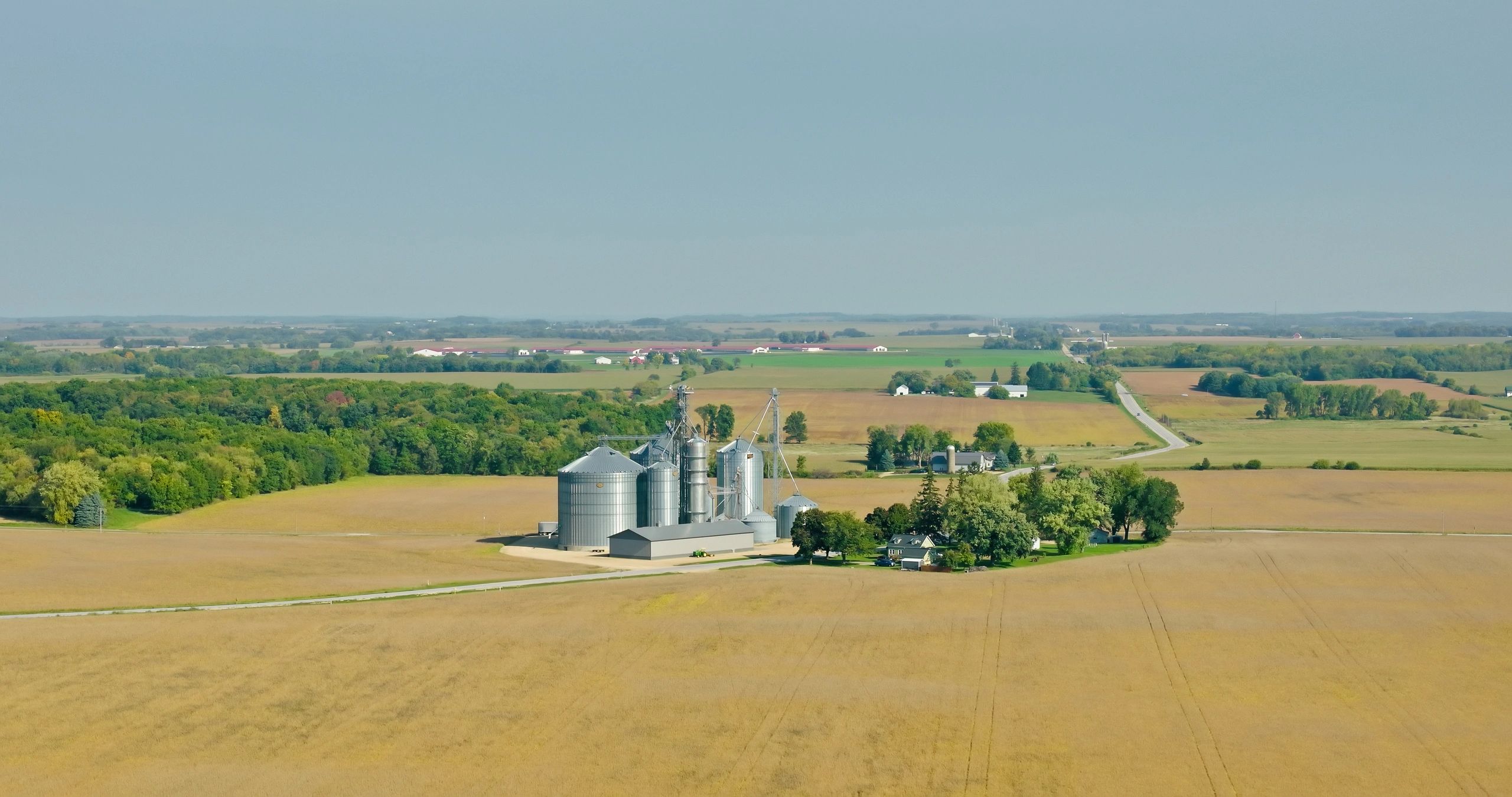Grain silos in farmland representing agricultural sourcing markets